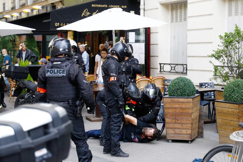 Police officers arrest a man during a demonstration in Paris, France, against the compulsory vaccination of people in some occupations.