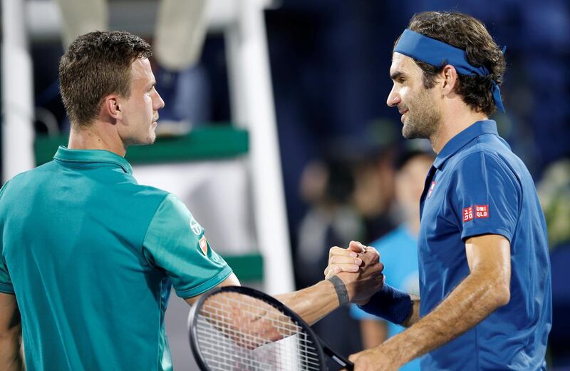 Federer is greeted by Fucsovics after winning their quarter-final match. EPA