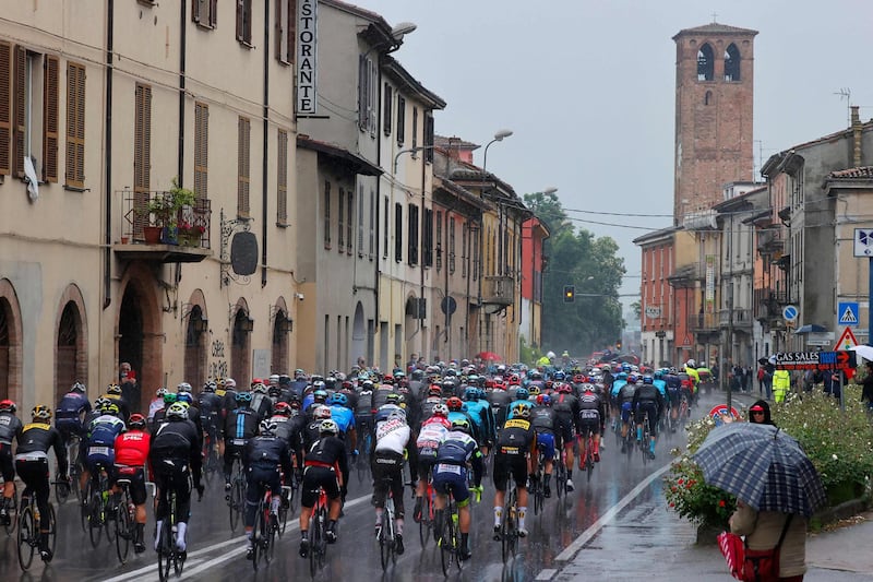 The peloton riding in pouring rain through the town of Pontenure. AFP