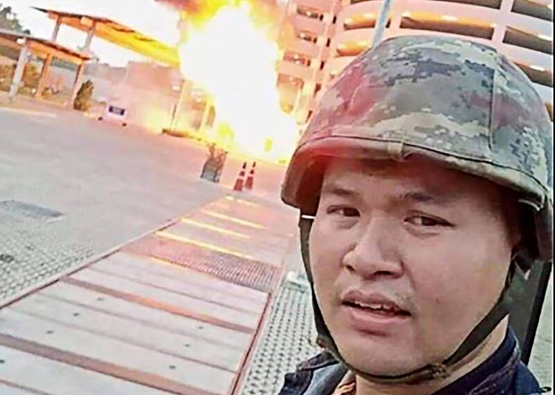 This screenshot made from the Facebook livestream video of Thai soldier Jakrapanth Thomma shows him standing in front of a building on fire during an attack in the northeastern city of Nakhon Ratchasima. AFP