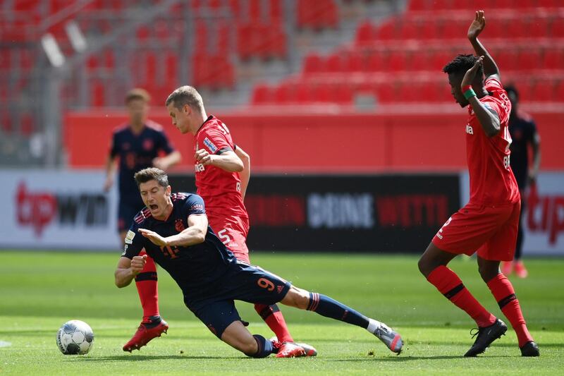 Bayern Munich striker Robert Lewandowski, left, is challenged by Sven Bender and Edmond Tapsoda from Leverkusen. AP