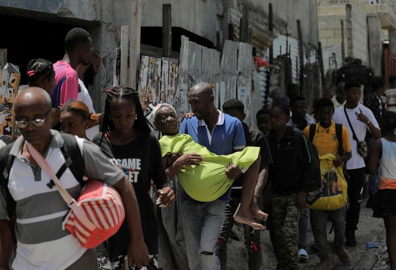 People carry their belongings as they flee their neighbourhood amid gang warfare in Port-au-Prince, Haiti. Reuters