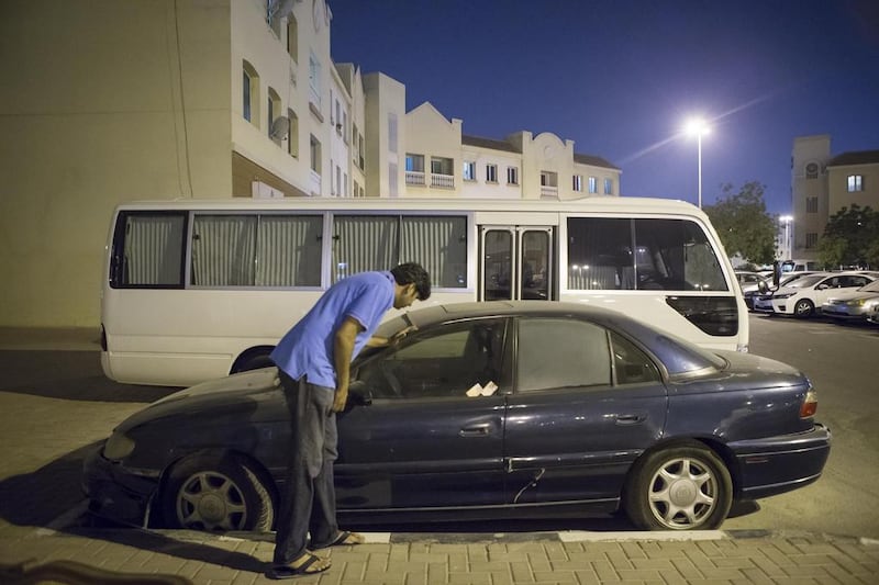 Arif Sibte, a resident, inspects an abandoned car in the English Cluster of International City in Dubai. Antonie Robertson / The National