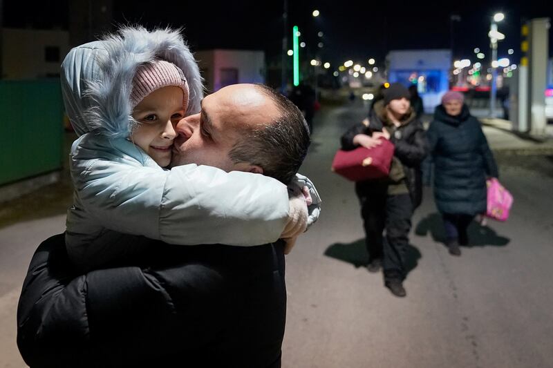 A father kisses his daughter after she, her mother and grandmother fled from the Russian invasion in Ukraine and crossed the border in Medyka, Poland. Reuters