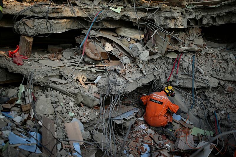 A Turkish rescue worker checks a collapsed building in Adiyaman. AP