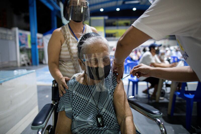 A senior citizen is vaccinated with the Moderna Covid-19 vaccine in a school-turned-vaccination site in Manila. Reuters