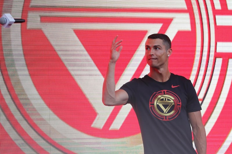 epa06897883 New Juventus soccer player Cristiano Ronaldo of Portugal throws a microphone  during his visit to Beijing, China, 19 July 2018. Ronaldo is in China for his annual 'CR7 tour'.  EPA/WU HONG