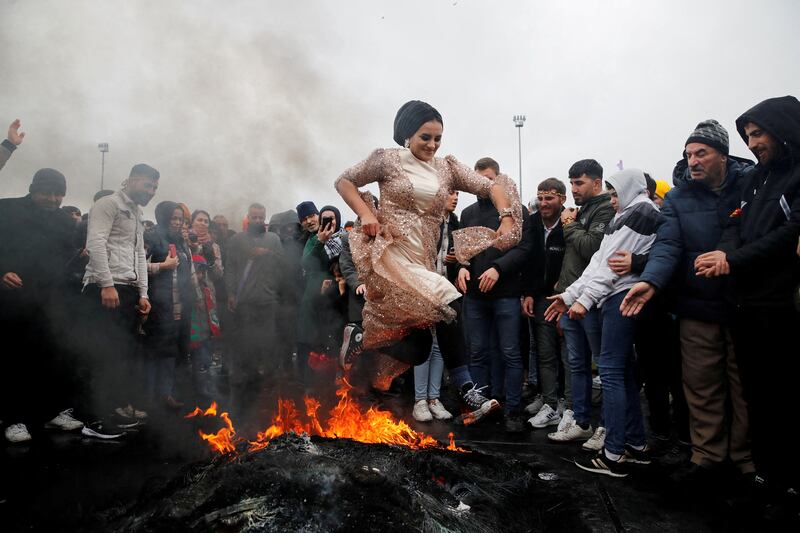 A woman leaps over a bonfire during Nowruz celebrations in Istanbul. In 2023, the Persian New Year falls on March 20. Reuters