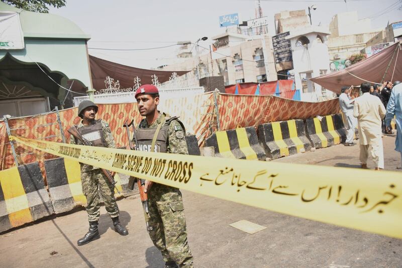 Pakistani security officials inspect the scene of a suicide bomb attack that targeted a police vehicle outside the Sufi Muslim Data Gunj Buksh shrine in Lahore. EPA