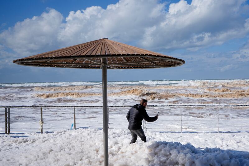 Sea foam covers parts of the boardwalk at the port on the Mediterranean Sea, in Tel Aviv, Israel, as strong winds and waves from Storm Barbara hit the country. AP