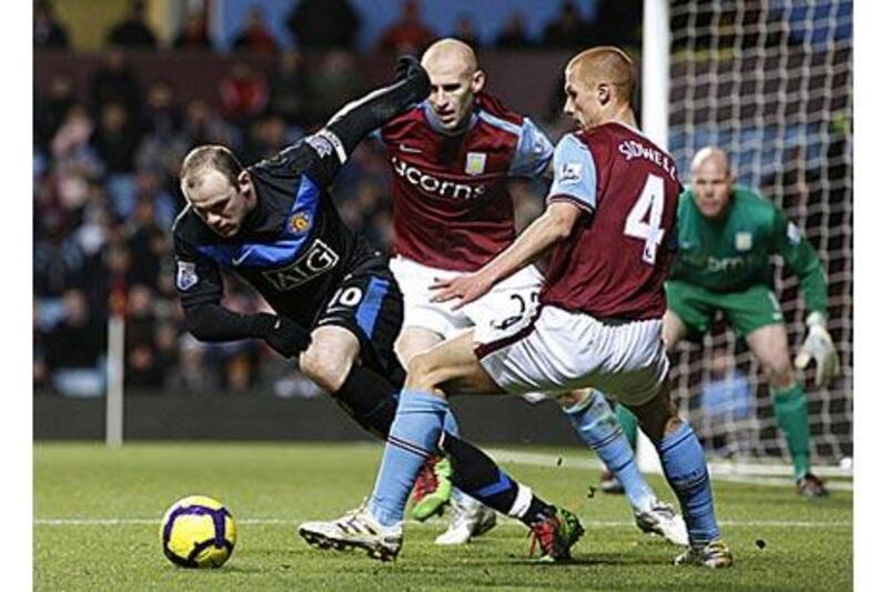 Manchester United's Wayne Rooney, left, tries to beat Aston Villa's Steve Sidwell, right, and James Collins when the two teams drew 1-1 earlier this month.