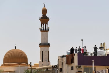 Workers pray together on the roof of a residential building in Dubai on Friday. AFP