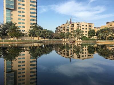 DUBAI, UNITED ARAB EMIRATES. 09 APRIL 2019. Standalone picture of buildings reflected in the water pools of The Greens in Dubai for Weekend Cover. (Photo: Antonie Robertson/The National) Journalist: None. Section: Weekend.