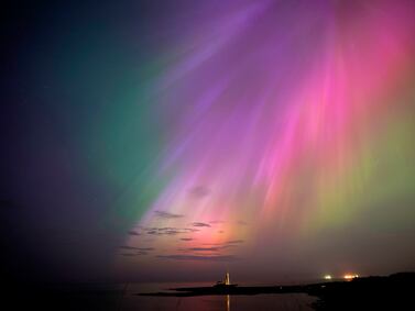 The aurora borealis, also known as the northern lights, glow on the horizon at St.  Mary's Lighthouse in Whitley Bay on the North East coast, England, Friday, May 10, 2024.  Brilliant purple, green, yellow and pink hues of the Northern Lights were reported worldwide, with sightings in Germany, Switzerland, London, and the United States and Canada.  (Owen Humphreys / PA via AP)