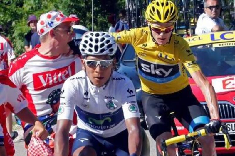 Yellow jersey holder Chris Froome pushes a spectator out of the way as he cycles behind Nairo Quintana, who won the 20th stage. Froome is now a simple ride into Paris away from winning the Tour de France.