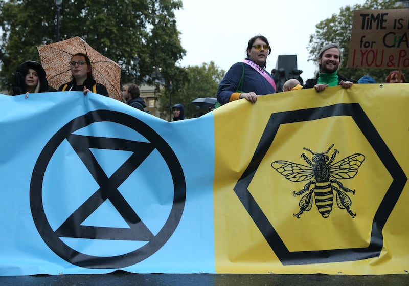 Climate change activists from the Extinction Rebellion block the road with a banner that calls on the government to act now to reduce greenhouse gas emissions to halt biodiversity loss and suggests the creation of citizen's assemblies on Whitehall outside Downing Street in central London, on October 7, 2019 during the group's global climate protests.  AFP / ISABEL INFANTES