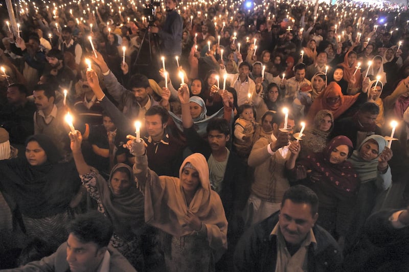 Pakistani Christians hold lighted candles as they hold a prayer ceremony at The Eternal Life Church in Lahore on December 16, 2015, on the first anniversary of an attack on Army Public School in Peshawar.  Pakistan's leader, speaking beneath portraits of children killed by Taliban bullets, called for vengeance as the country marked the first anniversary of a school massacre that killed 151 people in its worst-ever extremist attack. AFP PHOTO / Arif ALI (Photo by Arif Ali / AFP)