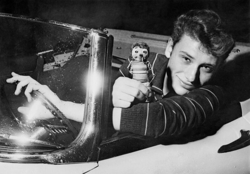 (FILES) This file photo taken in the 1960s shows French singer Johnny Hallyday posing his a car.
France's best-known rock star Johnny Hallyday has died aged 74 after a battle with lung cancer, his wife Laeticia told AFP on December 6, 2017. / AFP PHOTO / -