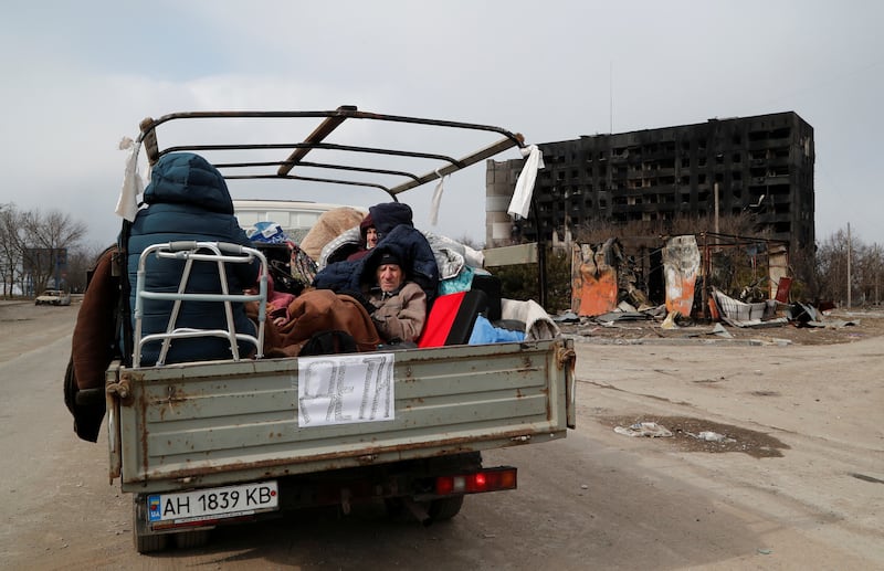 Evacuees fleeing Ukraine-Russia conflict sit in the body of a cargo vehicle while waiting to leave Mariupol. Reuters