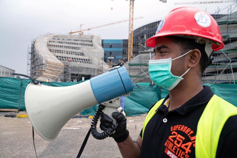 A supervisor  addresses labourers through a megaphone on a construction worksite in Ahmadi, Kuwait. Reuters