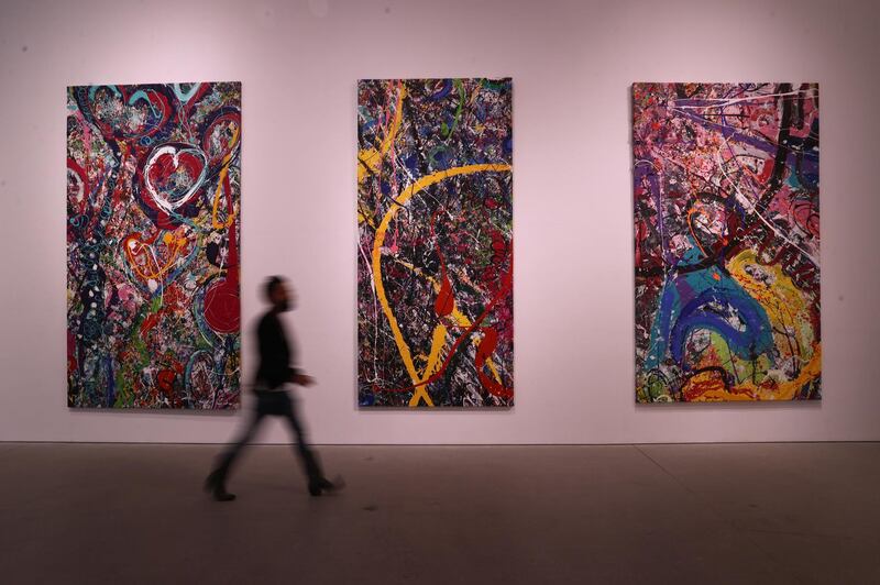 British artist Sacha Jafri walks past his artwork "The Journey of Humanity" at Dubai's Leila Heller Gallery. The painting was created over seven months as the world's largest canvas, then broken down into 70 separate pieces.  Getty Images