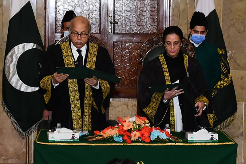 Chief Justice Gulzar Ahmed, left, administers the oath to Justice Ayesha Malik as Pakistan's first female supreme court judge in Islamabad. AFP