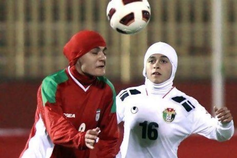 Shehnaz Jebreen, right, of the Jordan women's football team battles with Azar Mousaui of Iran for the ball. Prince Ali of Jordan, a member of Fifa's executive board, is pushing for the ban on wearing hijabs to be dropped.