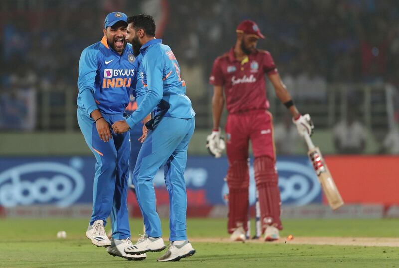 India's Rohit Sharma and Ravindra Jadeja, centre, celebrate the dismissal of Roston Chase during the second ODI in Visakhapatnam on Wednesday. AFP