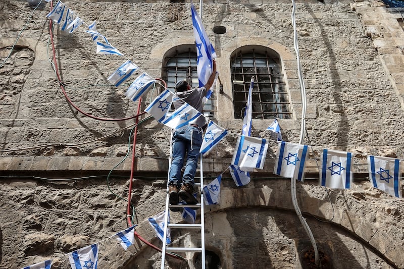 A man hangs Israeli flags in Jerusalem's Old City. Reuters
