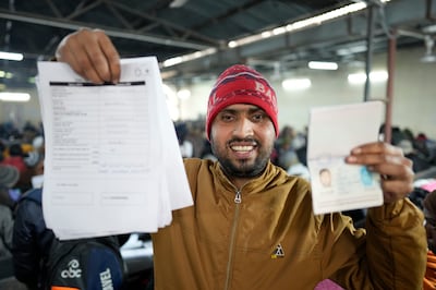 Anup Singh holds up his passport and application form for a job in Israel, at a recruitment event in Lucknow, northern India. AP