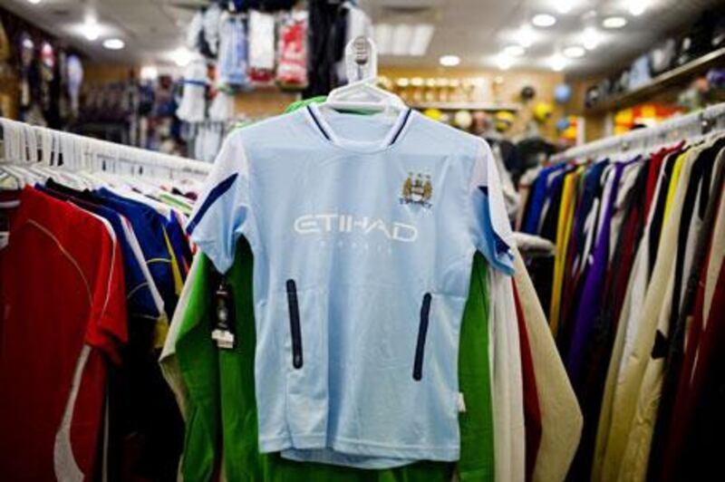 Imitation Manchester City shirts, like this one hanging in the Madinat Zayed shopping centre, will go on sale in Abu Dhabi today.