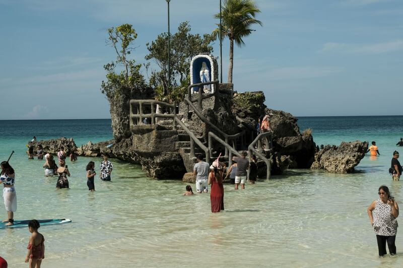 Tourists visit the Lourdes grotto on the main beach of Boracay island, Philippines. Bloomberg