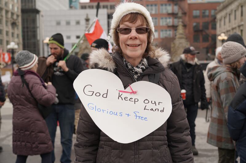 Donna Curry holds a sing saying 'God keep our land glorious and free' outside of Parliament.  Willy Lowry / The National