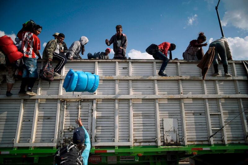 Central American migrants, mostly Hondurans, descend from a truck, on arrival at a temporary shelter in Irapuato, Guanajuato state, Mexico. AFP