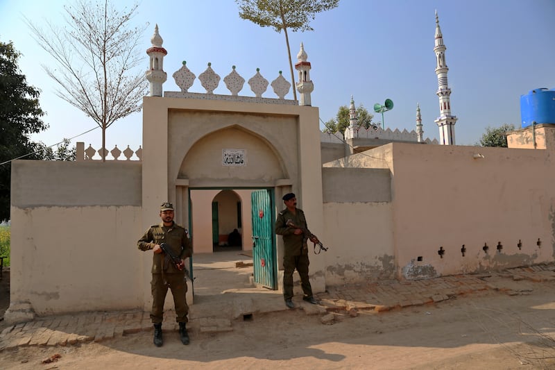 Police officers stand guard outside the mosque where the man was stoned to death. AP