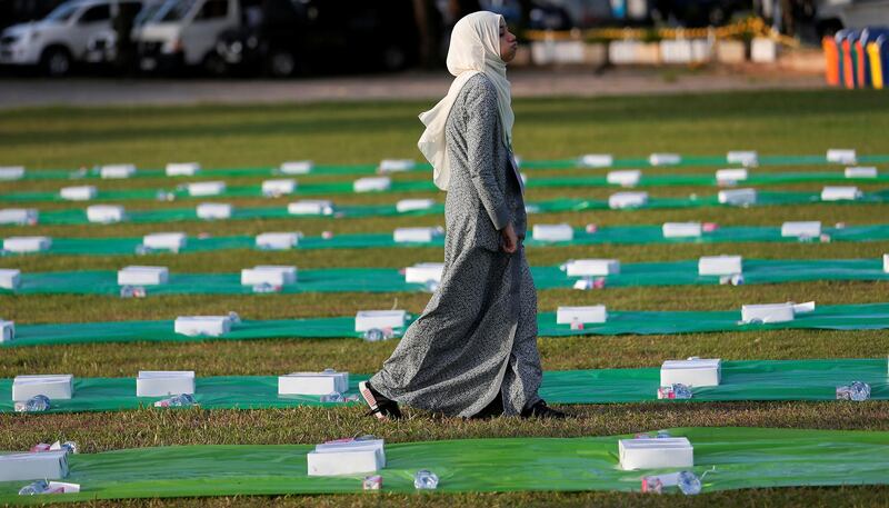 A Sri Lankan Muslim woman walks past food placed for devotees and Sri Lankan military, as they prepare to break their fast in Colombo, Sri Lanka. Reuters