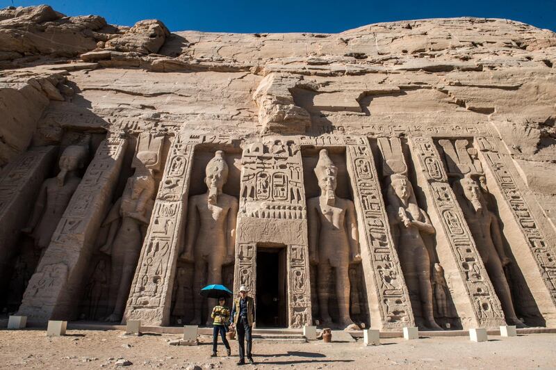 A picture taken on November 25, 2017 shows tourists exiting the Nefertari complex at the ancient Egyptian temple of Abu Simbel, some 1120 kilometres south of the Egyptian capital Cairo. - The UNESCO World Heritage Site temples, originally carved out of the rocky mountainside during the reign of the 19th dynasty in the 13th century BC, were relocated to higher ground in 1968 on an artificial hill made from a domed structure to avoid being flooded during the creation of the Lake Nasser reservoir as the Aswan High Dam was being built. (Photo by KHALED DESOUKI / AFP)