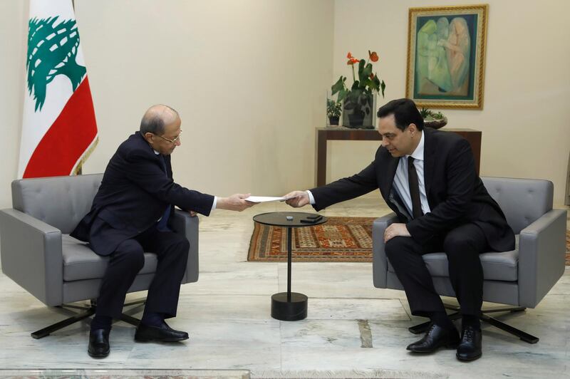 In this photo released by Lebanon's official government photographer Dalati Nohra, Lebanese President Michel Aoun, left, receives a letter of resignation from Lebanese Prime Minister Hassan Diab, at the presidential palace, in Baabda, east of Beirut, Lebanon, Monday, Aug. 10, 2020. Lebanon's prime minister stepped down from his job on Monday in the wake of the disastrous Beirut port explosion that triggered public fury, saying he has come to the conclusion that corruption in Lebanon is "bigger than the state." (Dalati Nohra via AP)