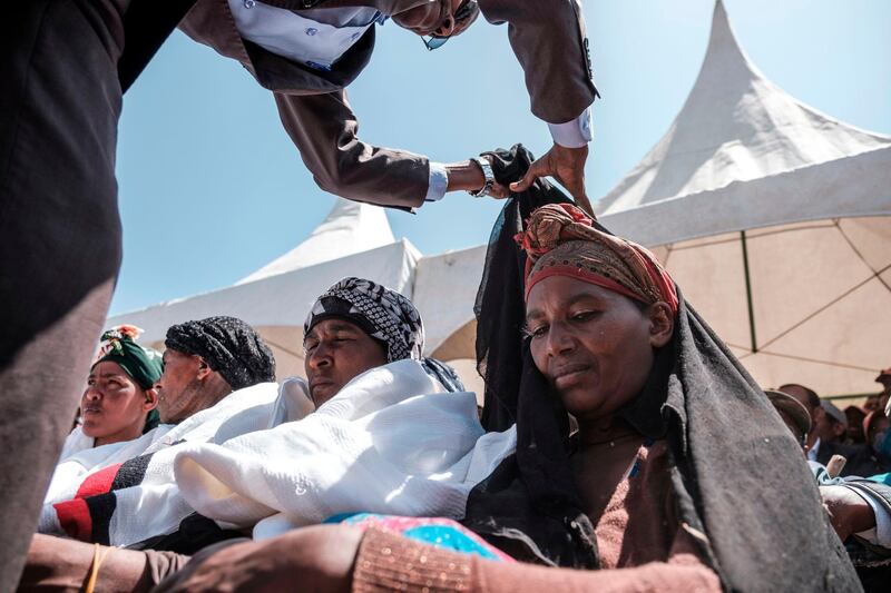 A man pulls out a mourning cloth from a woman during a memorial ceremony at the crash site of the Ethiopian Airlines Flight 302 airplane accident in Tulu Fara, Ethiopia.  AFP
