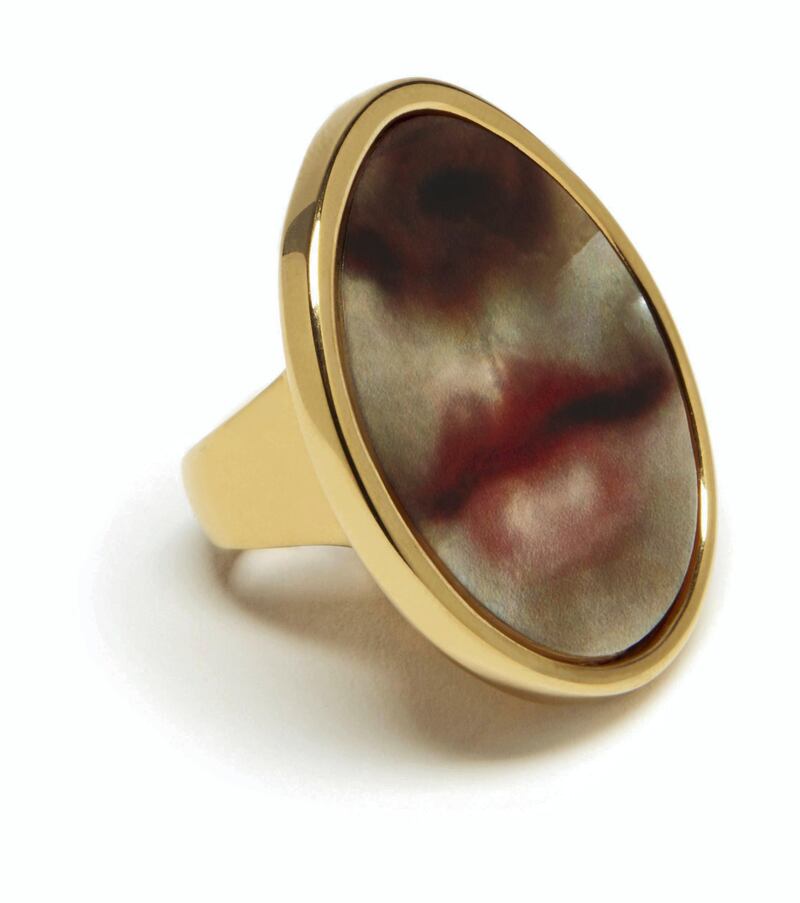An oval-shaped ring is decorated with a picture of rosebud lips.