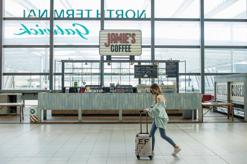 A traveler pushes a suitcase past a closed cafe near the check-in desks at London Gatwick Airport in Crawley, U.K., on Monday, June 22, 2020. European airlines are in a worse situation than previously estimated as the coronavirus crisis depresses travel markets, according to economists at the International Air Transport Association. Photographer: Jason Alden/Bloomberg