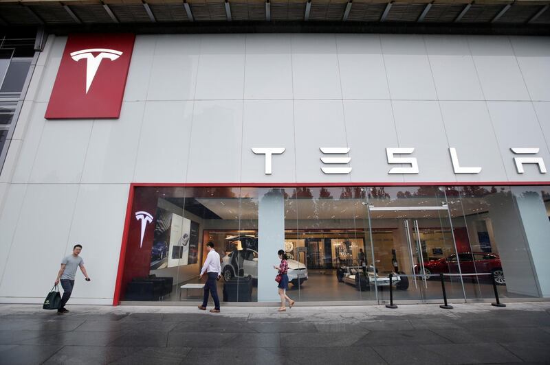 People walk past a showroom outside Tesla China headquarters at China Central Mall in Beijing, China July 11, 2018. REUTERS/Jason Lee