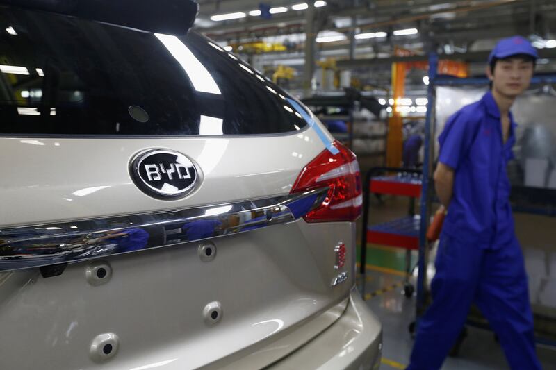 FILE PHOTO: A worker passes  by a car being manufactured at a BYD assembly line in Shenzhen, China May 25, 2016.   REUTERS/Bobby Yip/File Photo