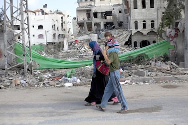 Palestinians in northern Gaza pass by a home damaged by an Israeli air strike. Heidi Levine for The National.
