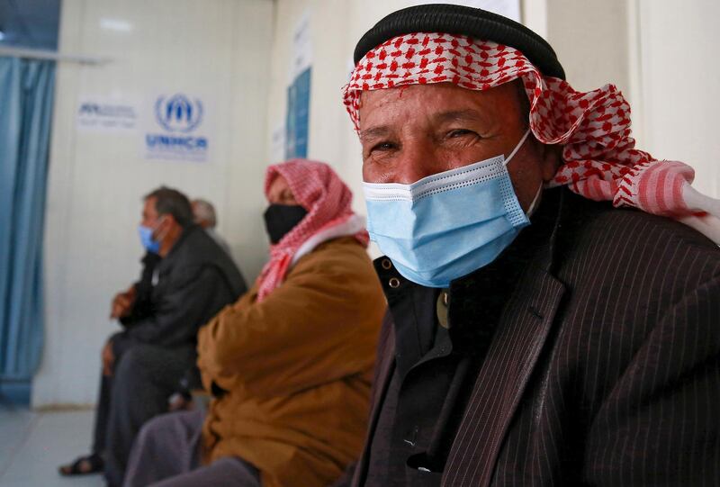 Syrian refugees wait to receive their Coronavirus vaccine, at a medical center in the Zaatari refugee camp, 80 kilometers (50 miles) north of the capital Amman on February 15, 2021.  / AFP / Khalil MAZRAAWI
