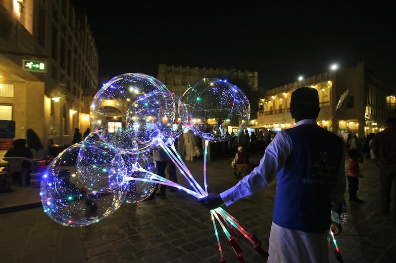 In this Thursday, May 3, 2018 photo, a vendor sells balloons at the Waqif Souq, or market, in Doha, Qatar.  The United Nations' highest court on Wednesday June 27, 2018, began hearing a lawsuit by Qatar accusing the United Arab Emirates of "discrimination against Qatar and Qatari citizens" amid a yearlong boycott by four Arab nations. (AP Photo/Kamran Jebreili)