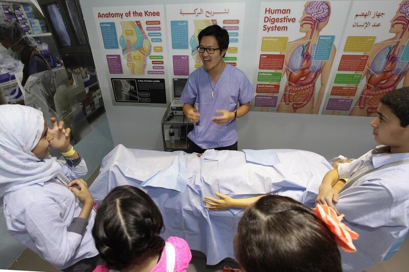 Dr Lewis Hou, a researcher at the University of Edinburgh, gives young visitors to the Abu Dhabi Science Festival the lowdown on emergency procedures before allowing them to ‘operate’ on a medical dummy ‘injured’ in a cycling accident. Jeffrey E Biteng / The National