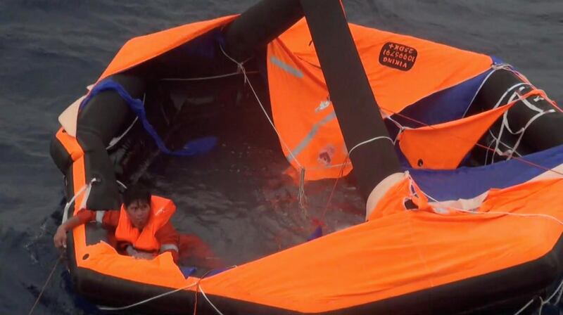 A Filipino crew member waits to depart the life raft during rescue by Japan Coast Guard crew onto the vessel Kaimon. Reuters