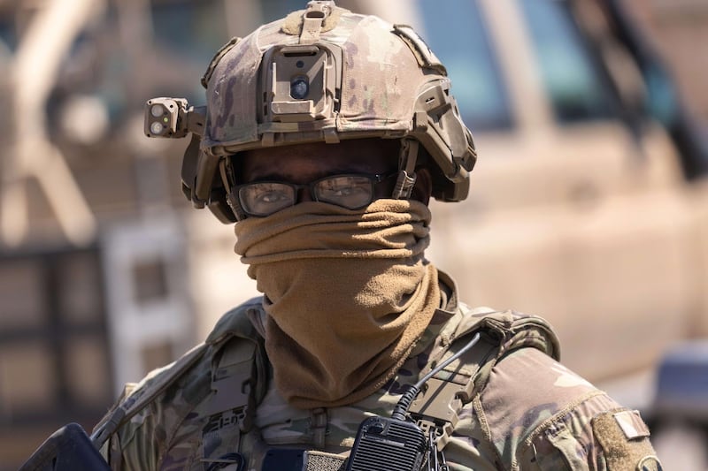 NORTHEASTERN SYRIA - MAY 26: A U.S. Army soldier stands guard as his commanding officer and allied troops meet with local villagers on May 26, 2021 near the Turkish border in northeastern Syria. U.S. forces, part of Task Force WARCLUB operate from remote combat outposts in the area, coordinating with the Kurdish-led Syrian Democratic Forces (SDF) in combatting residual ISIS extremists and deterring pro-Iranian militia.   John Moore/Getty Images/AFP
== FOR NEWSPAPERS, INTERNET, TELCOS & TELEVISION USE ONLY ==
