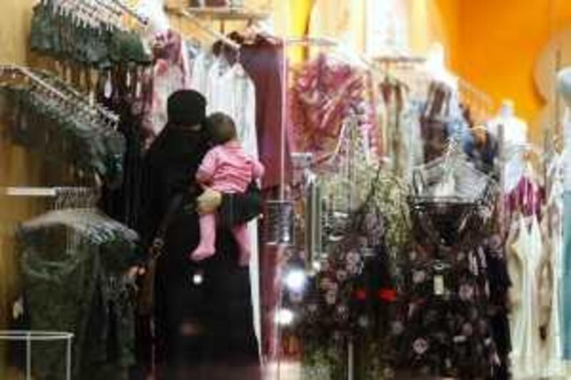 A Saudi woman holding a child checks out lingerie at a store in Riyadh, Saudi Arabia, Wednesday, March 25, 2009. A group of Saudi woman launched a campaign Tuesday aimed at bringing in female sales personnel at lingerie stores. Only men are allowed to sell underwear in almost all stores in this ultraconservative kingdom, making the experience of shopping for intimate apparel for most women embarrassing.  (AP Photo/Hassan Ammar)